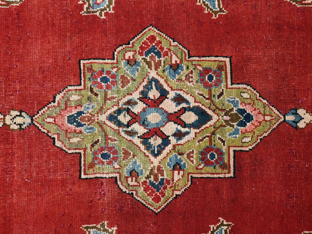 a close up of a red rug with a design on it