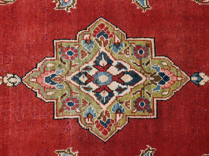 a close up of a red rug with a design on it