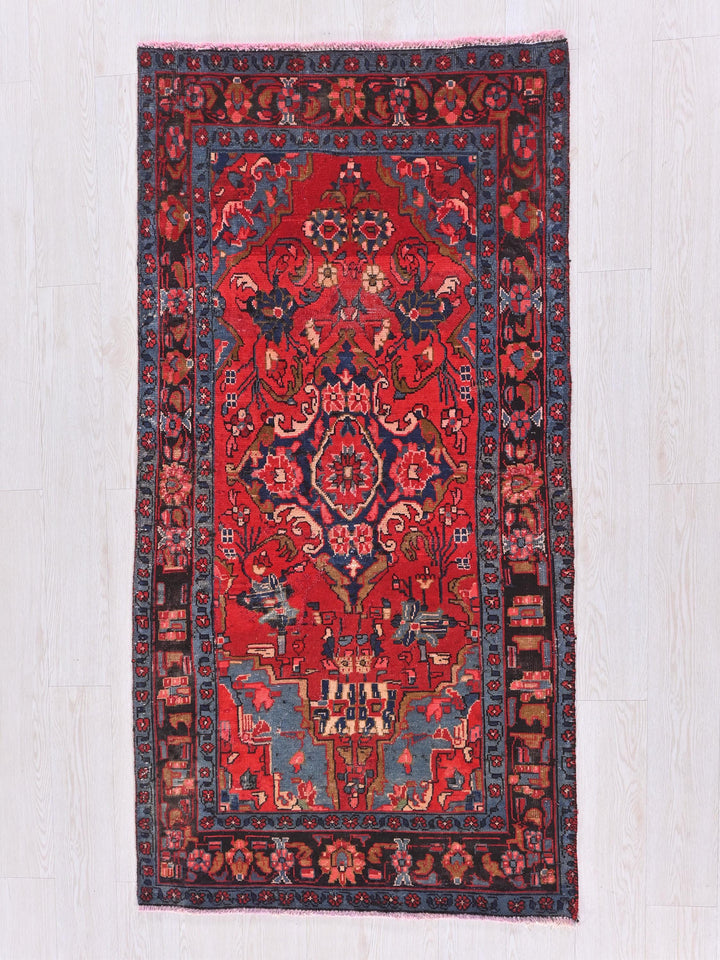 a red and blue oriental rug on a wooden floor