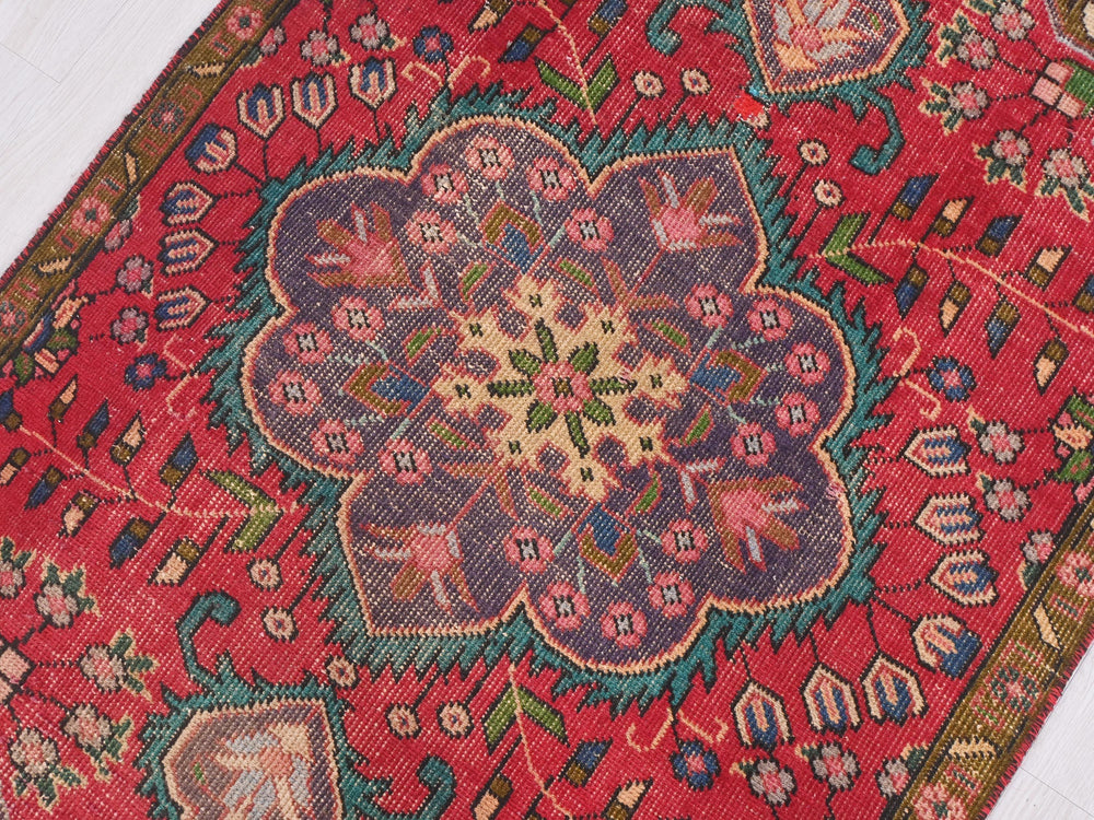 a red rug with a flower design on it