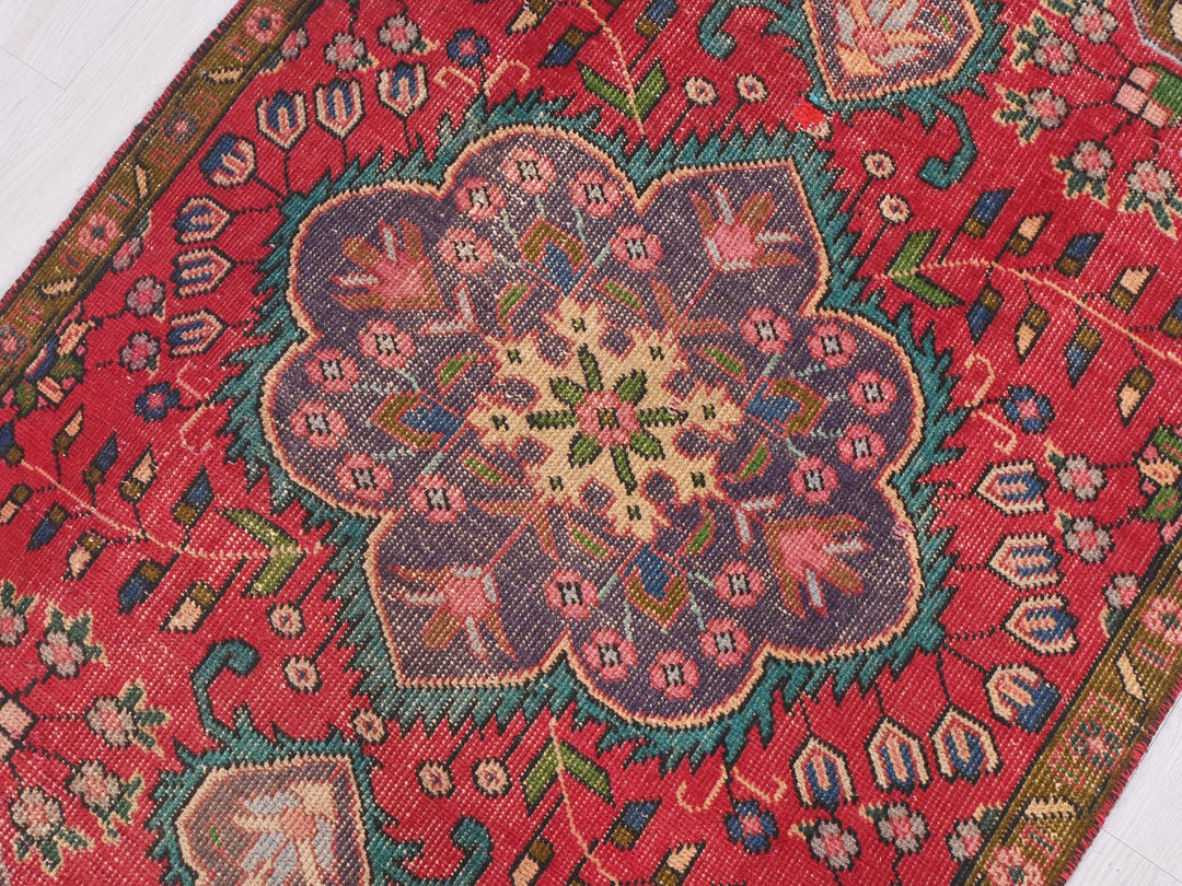 a red rug with a flower design on it