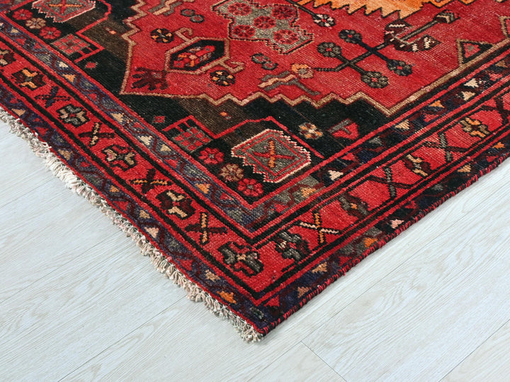 a red and black rug on a white floor