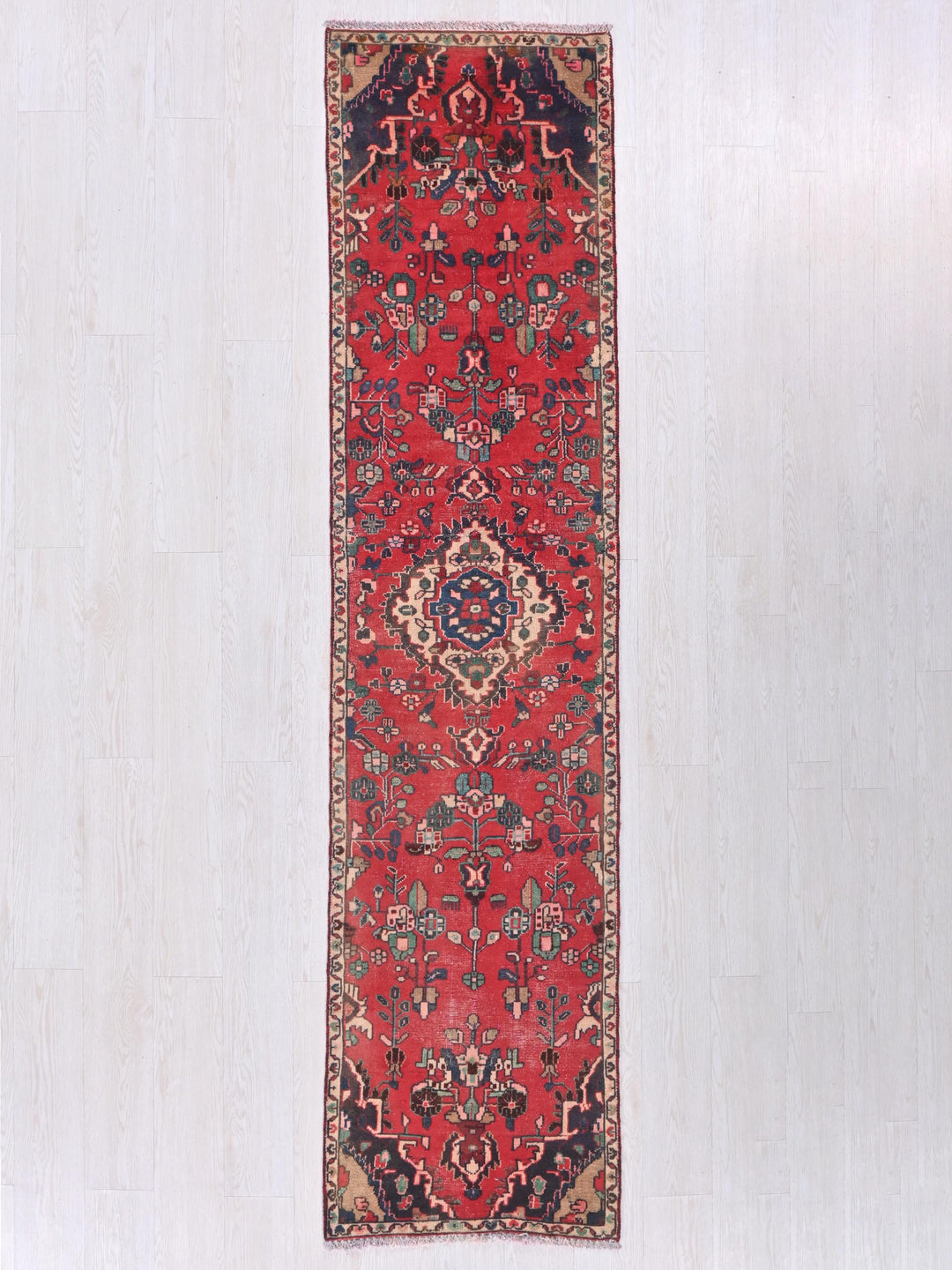 a long red rug hanging on a wall