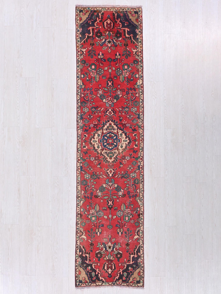 a long red rug hanging on a wall