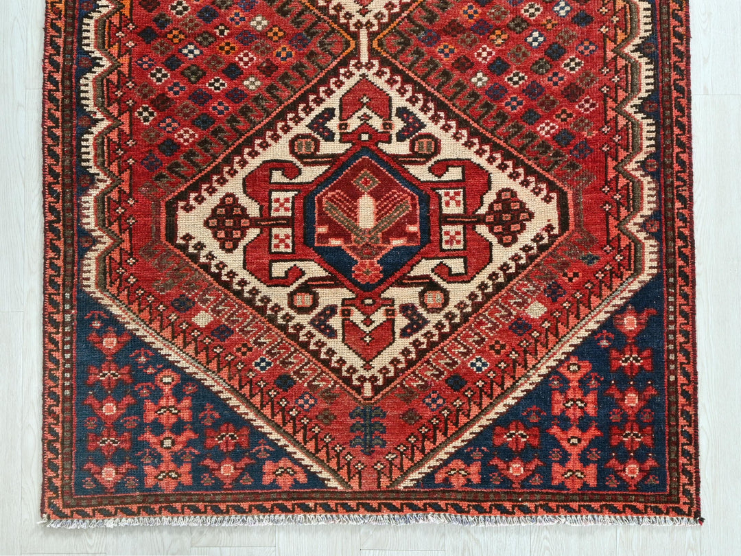 a red and blue rug on a white floor