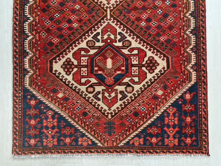 a red and blue rug on a white floor