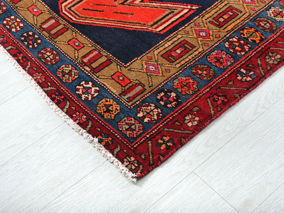 a red and blue rug on a white floor