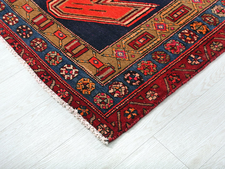 a red and blue rug on a white floor