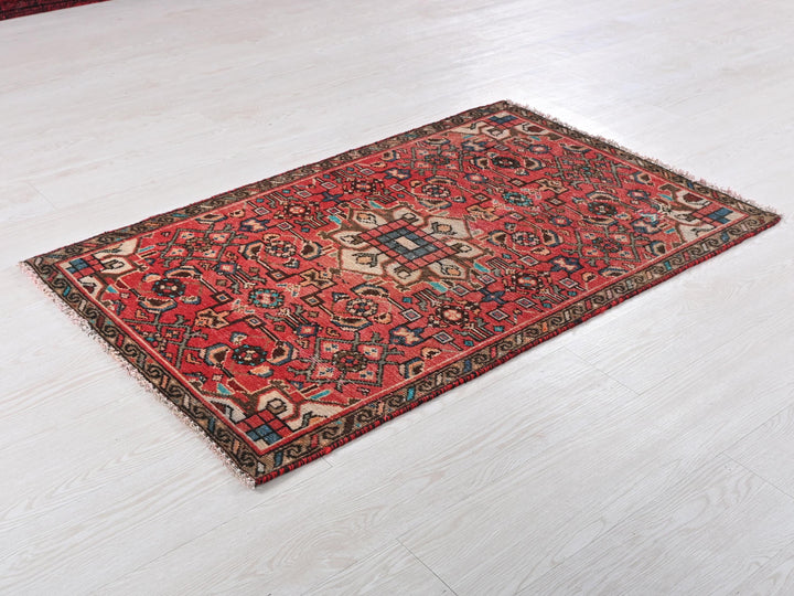 a red rug is laying on a white floor
