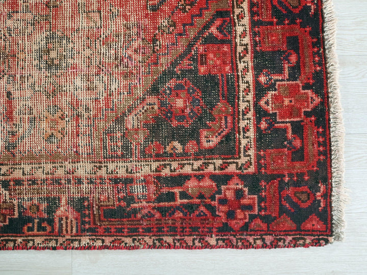 a red and black rug on a white floor