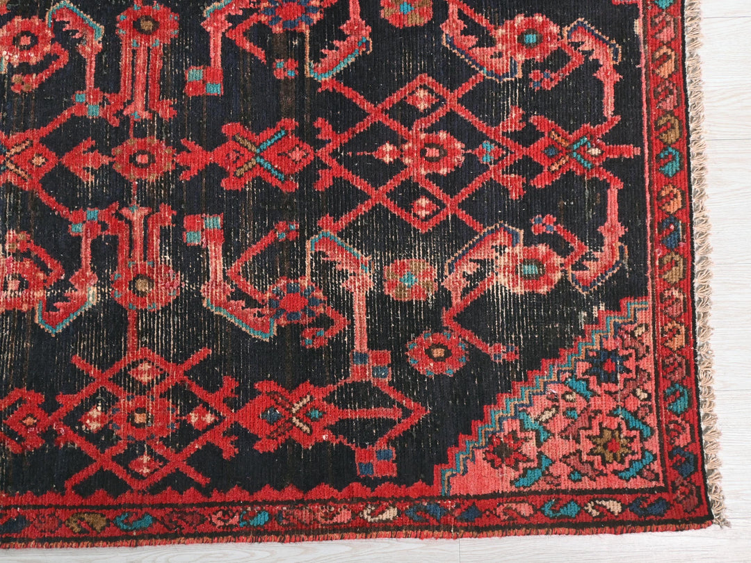 a red and black oriental rug on a white floor