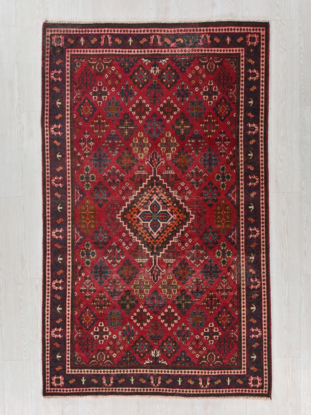 a red rug with a diamond pattern on it
