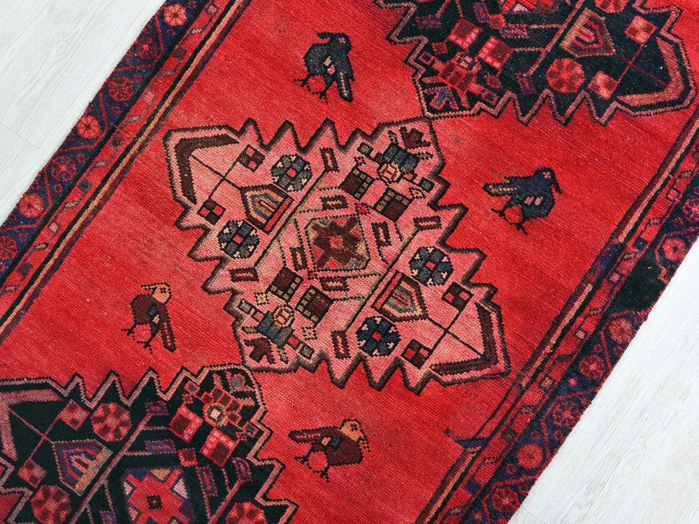a red rug with a design on the middle of it