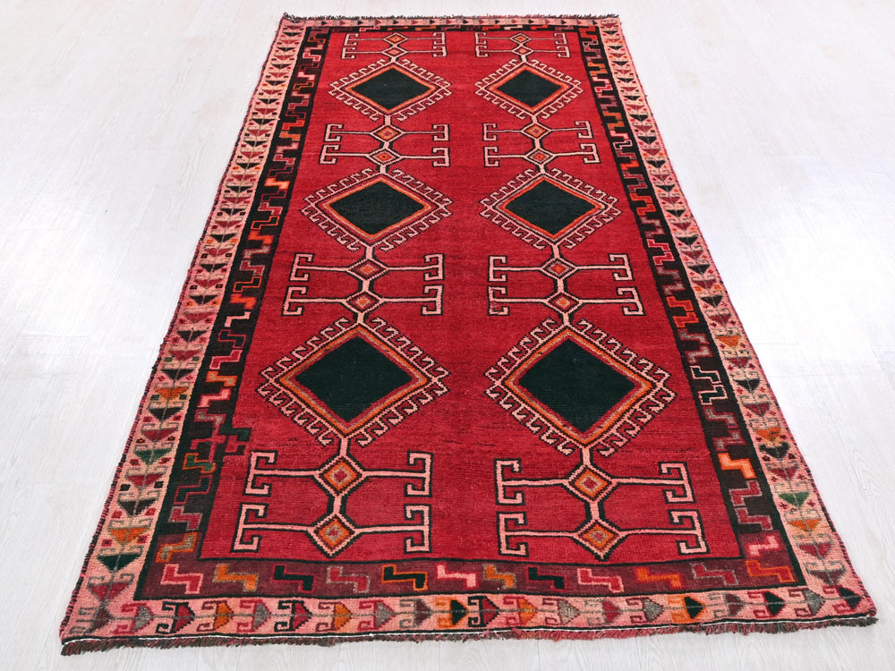 a red and black rug on a white floor
