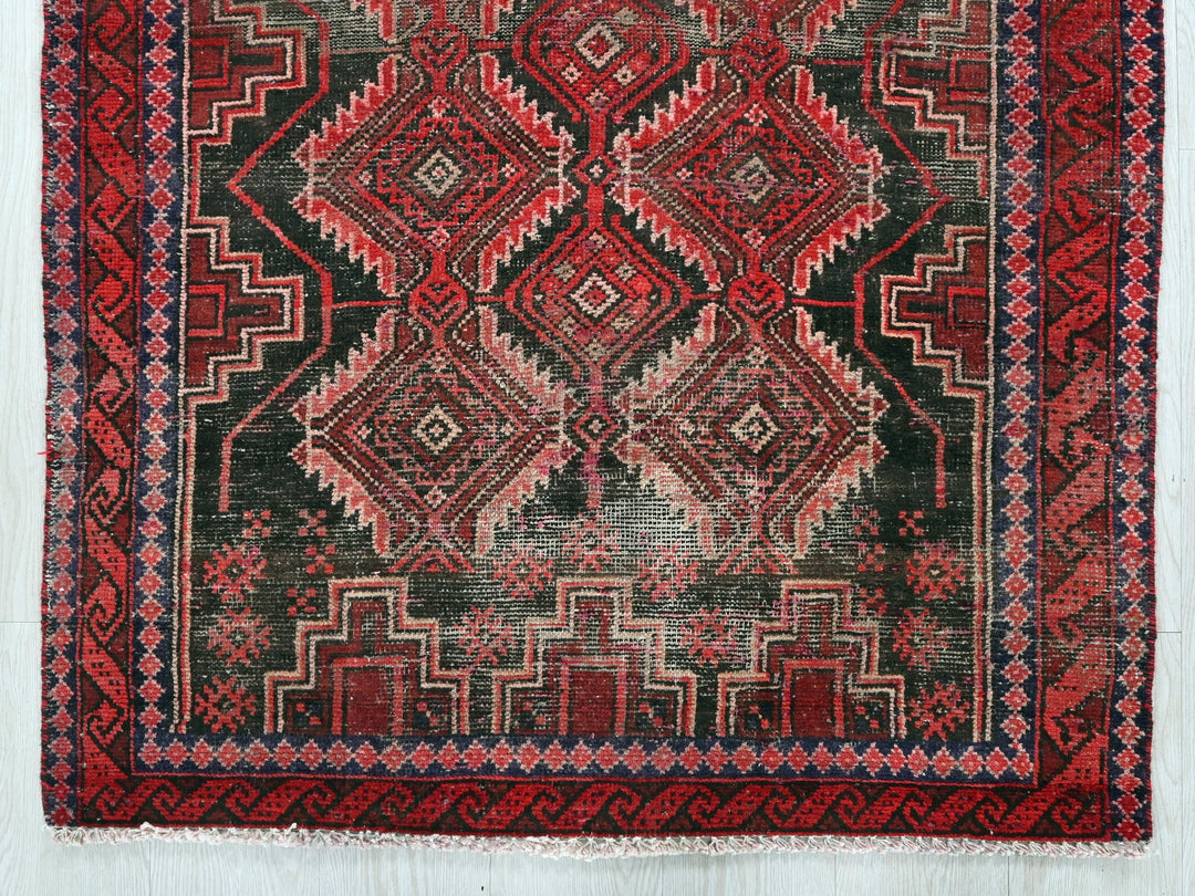 a red and black rug on a white surface