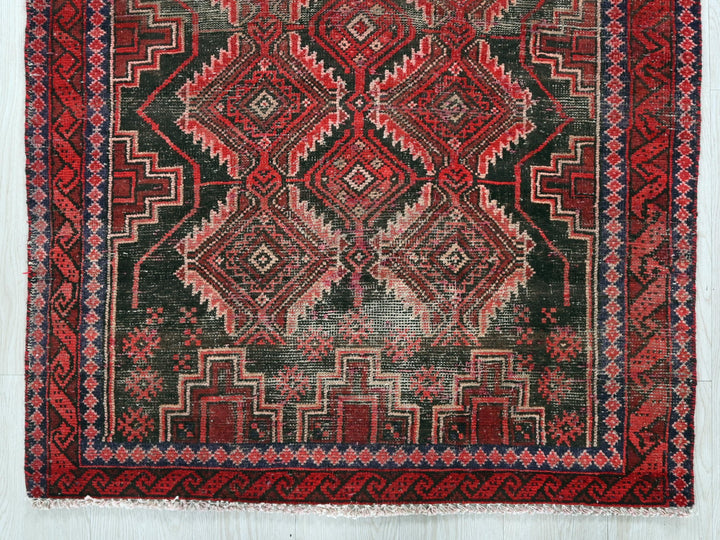 a red and black rug on a white surface