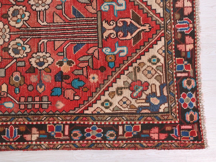 a red oriental rug on a white wooden floor
