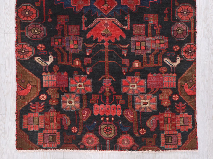 a red and black rug with a bird on it