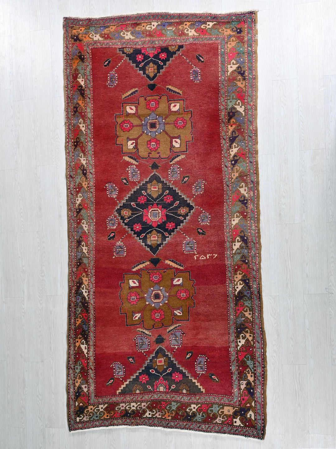 a red oriental rug hanging on a wall