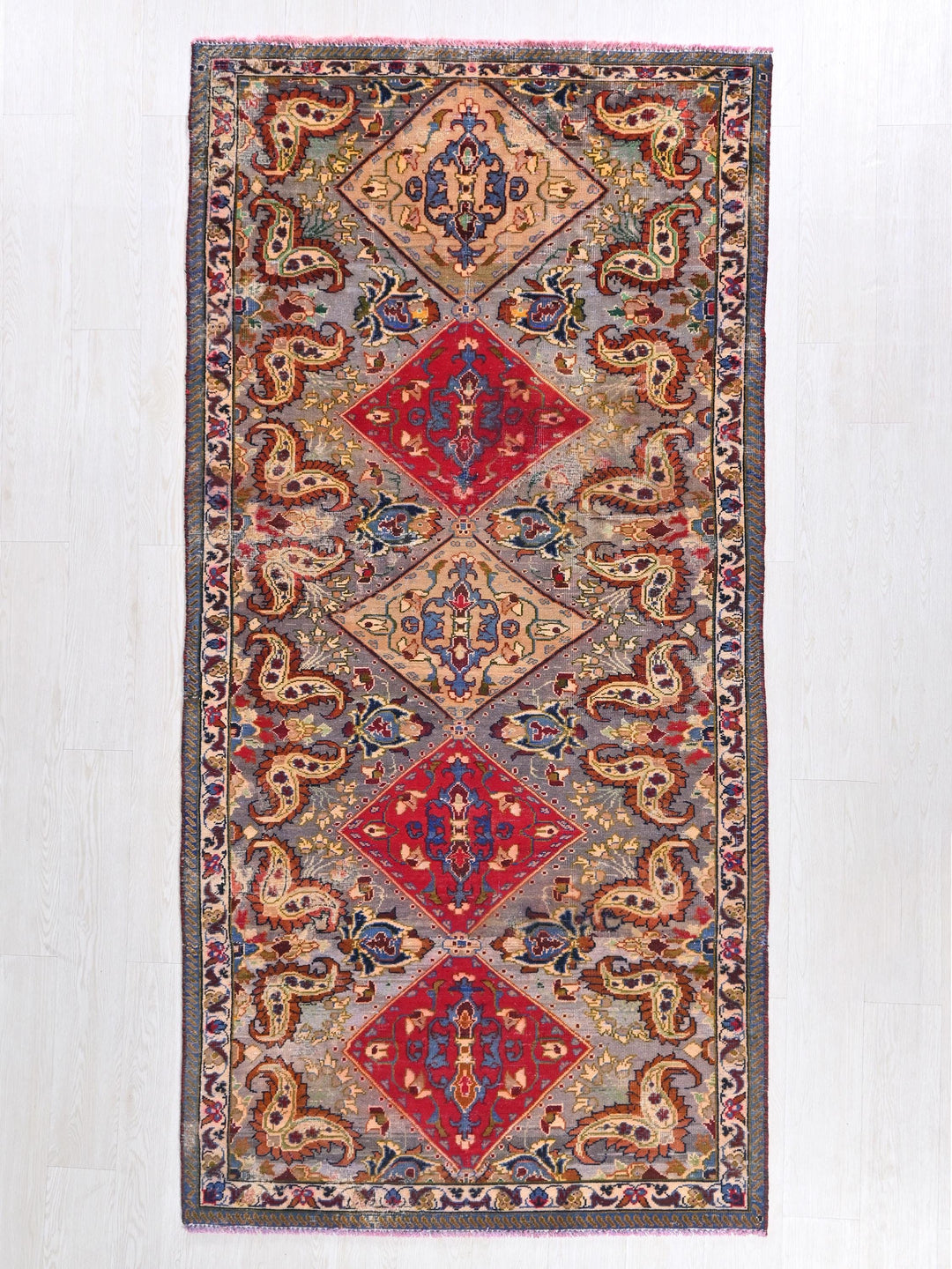 a red, blue, yellow, and green rug on a white wall