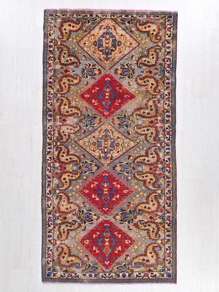 a red, blue, yellow, and green rug on a white wall