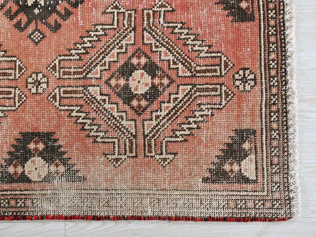 a red rug with a black and white design on it