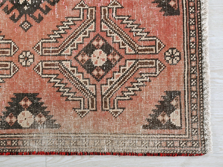 a red rug with a black and white design on it