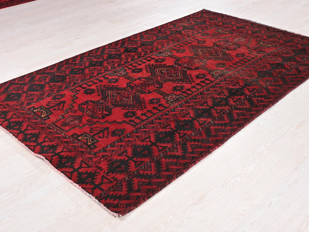 a red and black rug on a white floor