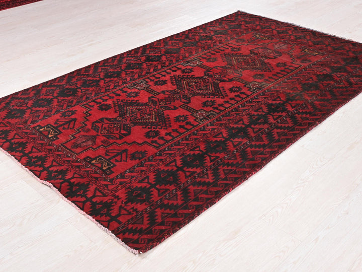a red and black rug on a white floor