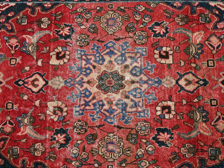 a red rug with a floral design on it