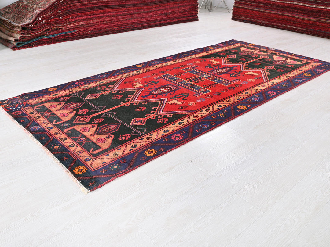 a red and black rug on a white floor