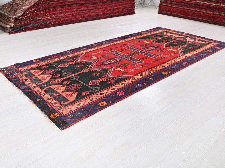 a red and black rug on a white floor