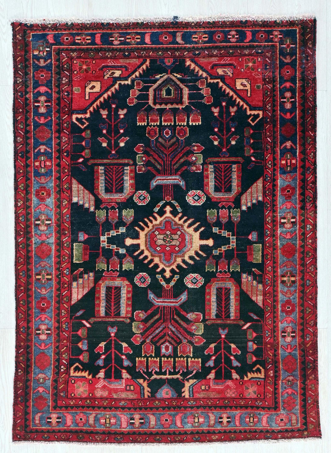an antique persian rug with red and blue colors