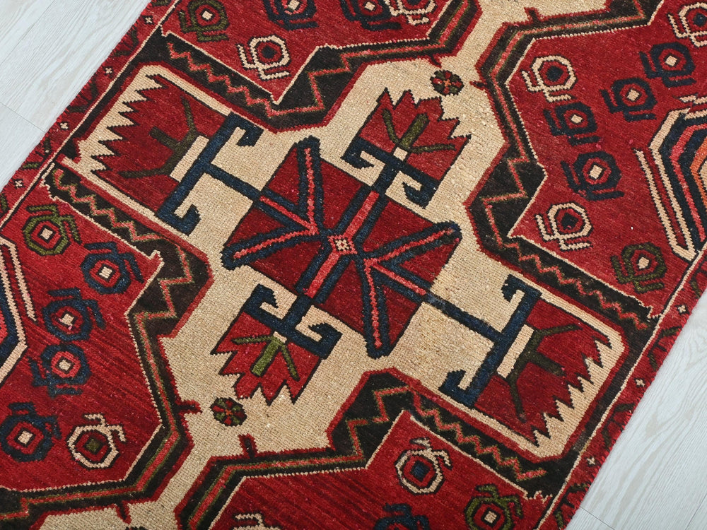 a red and black rug on a white floor