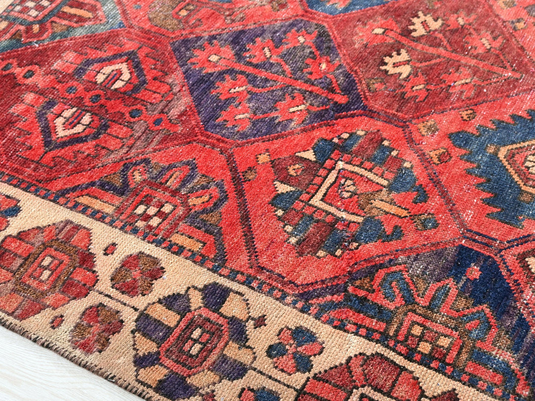 a red and blue rug on a wooden floor