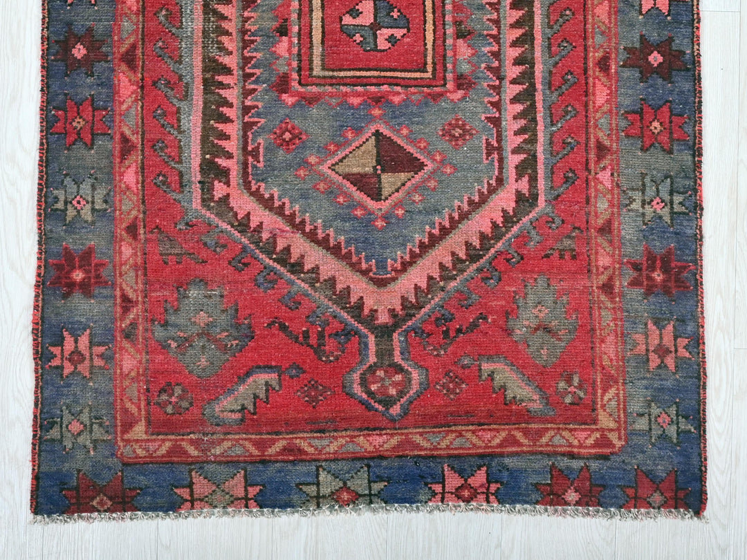 a red and blue rug with a design on it