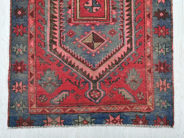 a red and blue rug with a design on it