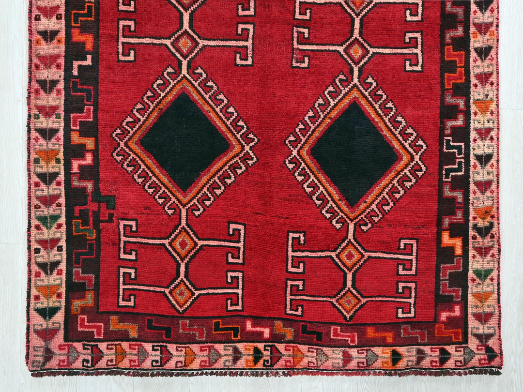 a red rug with a black diamond in the middle