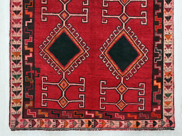 a red rug with a black diamond in the middle
