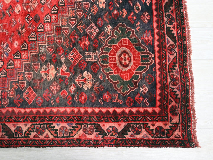 a red and black oriental rug on a white floor