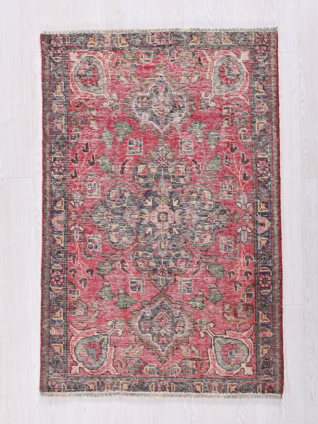 a red and blue rug on a white floor