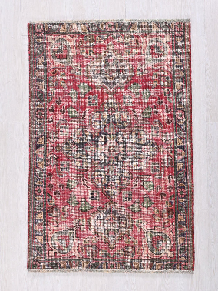 a red and blue rug on a white floor
