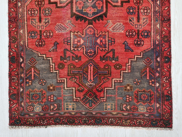 a red rug with a design on the middle of it
