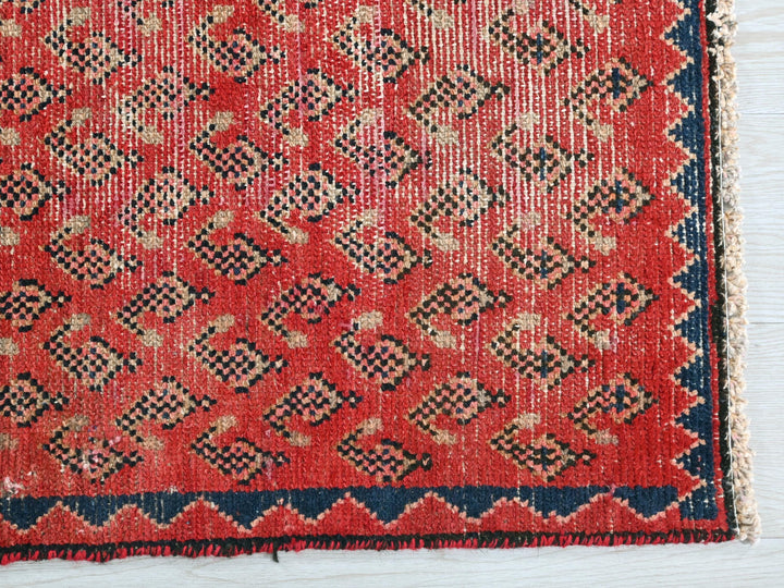 a red and blue rug on a white surface