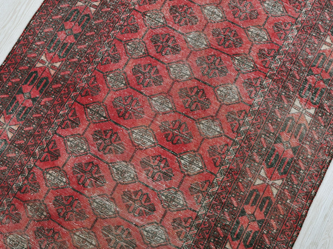 a red and black rug on a white floor