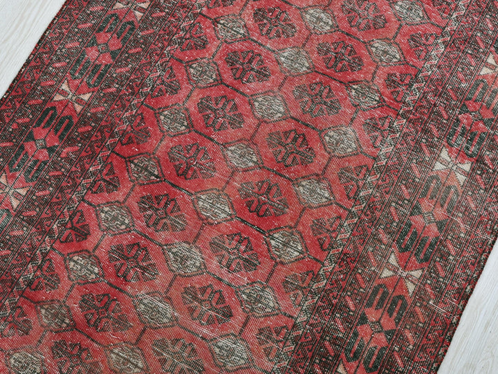 a red and black rug on a white floor