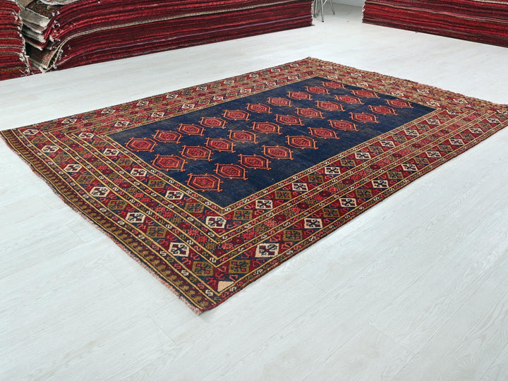 a pile of red and blue rugs sitting on top of a white floor