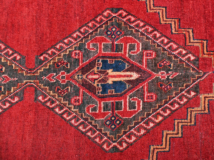 a close up of a red rug with a design on it