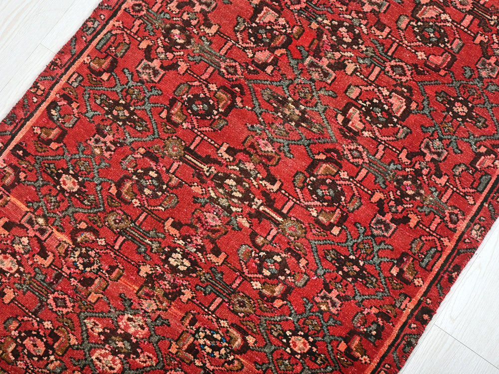 a red rug on a white wooden floor