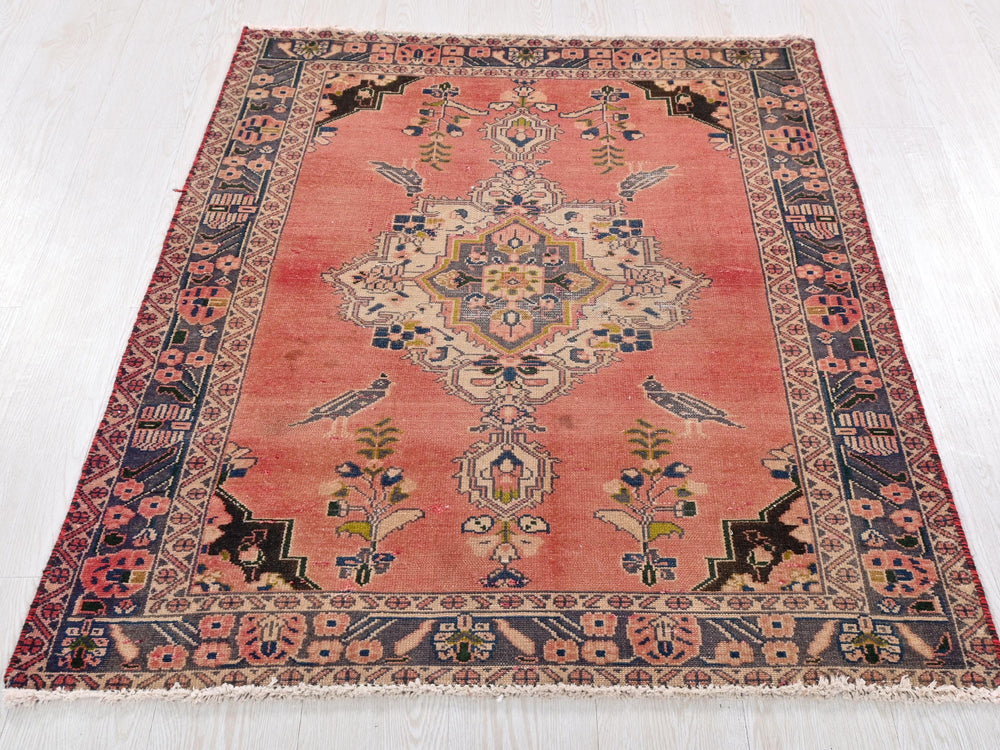a red rug with an intricate design on a white floor